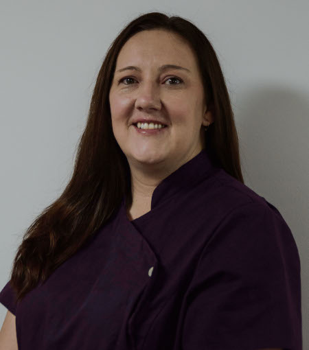 Portrait of smiling dentists standing with arms crossed in dental clinic